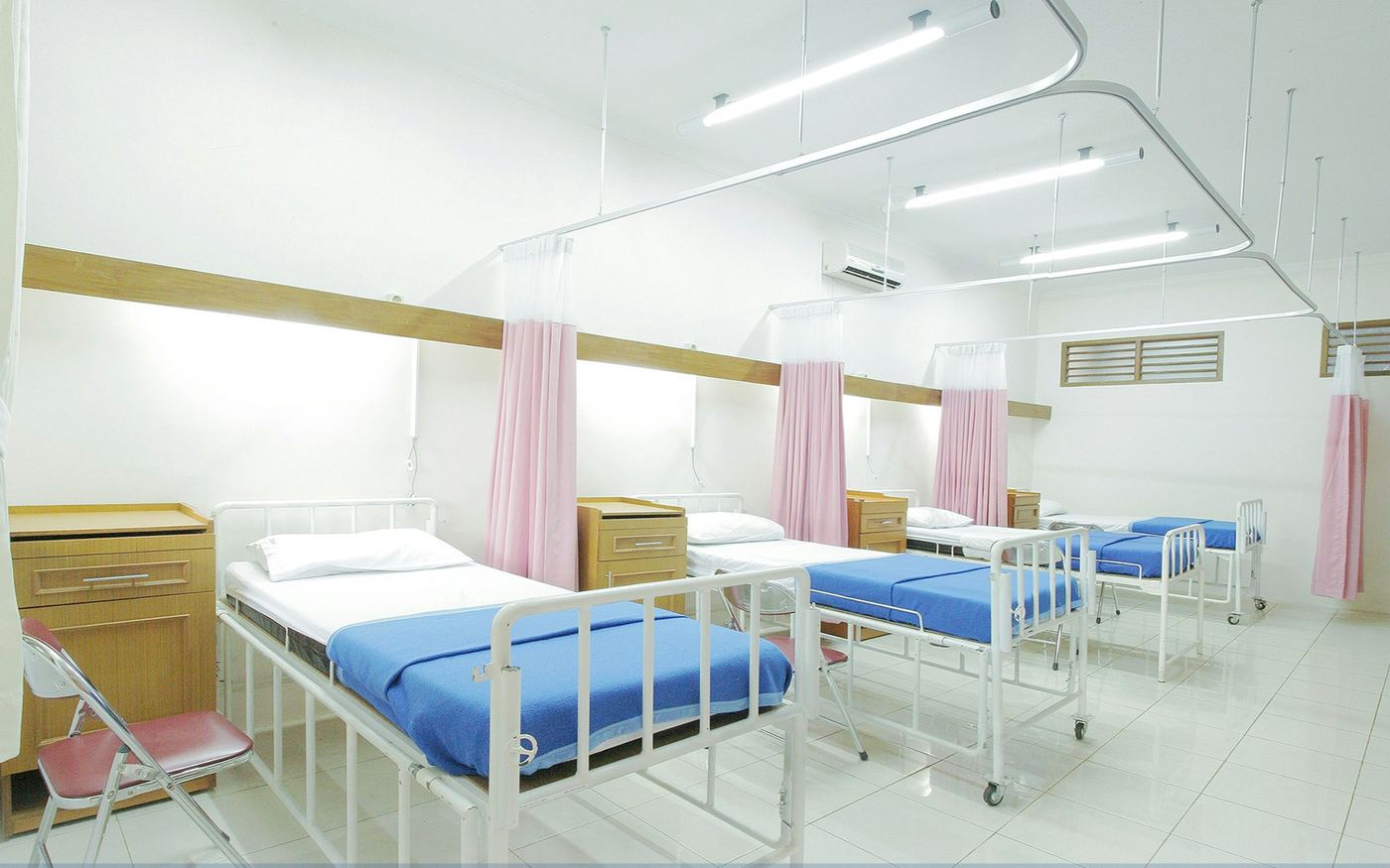 Sala de hospitalización con camas y cortinas rosadas